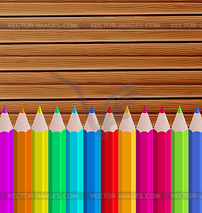 Palette pencils on wooden background - vector image