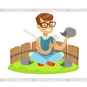 Happy little boy sitting on green grass and - vector clip art