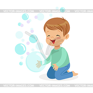 Happy boy kneeling playing bubbles - vector clip art