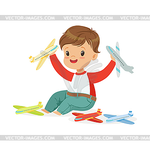 Adorable happy little boy sitting on floor playing - vector image