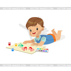 Happy smiling little boy lying on his stomach and - vector clipart