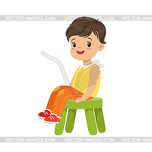 Cute little boy sitting on small green stool, - vector image