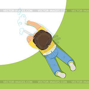 Little boy lying on his stomach and drawing clouds - vector image