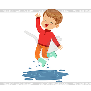 Cute little boy playing on puddle wearing rubber - vector clipart