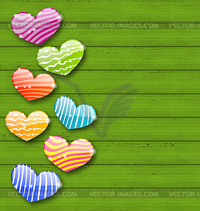 Multicolored striped hearts on green wooden - vector clipart / vector image