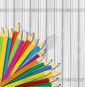 Varicoloured pencils on background wooden texture - vector image