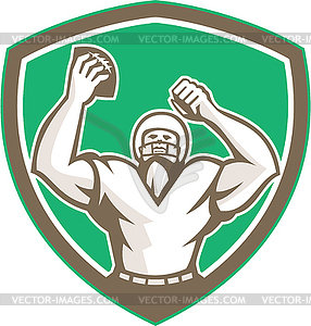 American Football Holding Ball Celebrating Shield - vector clipart