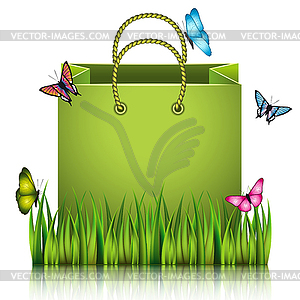 Green paper shopping bag on meadow grass - vector image