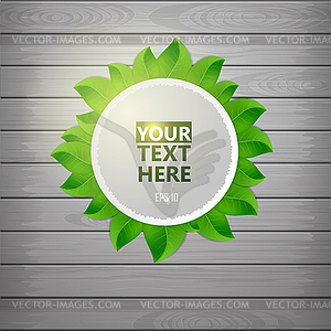 Paper label with green leaf on wooden texture - vector image